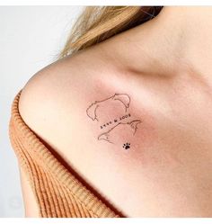 a woman's shoulder with a dog paw tattoo on the left side of her chest