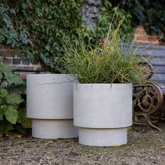 two cement planters sitting next to each other