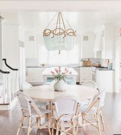 a dining room table with chairs and a chandelier hanging from the ceiling above it