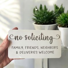 a hand holding a sign that says no soliciing family, friends, neighbors and deliveries welcome