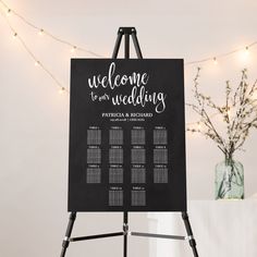 a welcome to our wedding sign with lights in the background