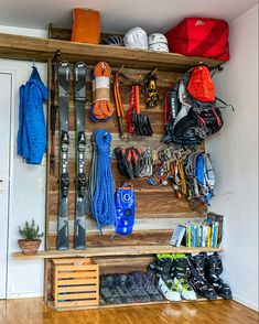 a wooden shelf filled with lots of sports items and equipment on top of a hard wood floor