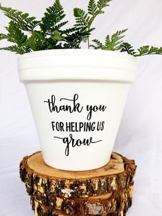 a white flower pot with the words thank you for helping us grow on it