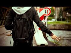 a man walking down the street with his back to the camera and holding his hands out