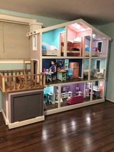 a doll house with lots of furniture and accessories in the middle of a wooden floor