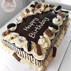 a birthday cake with white frosting and chocolate toppings on it's top