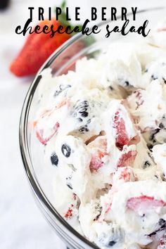 a bowl filled with fruit salad next to a strawberry