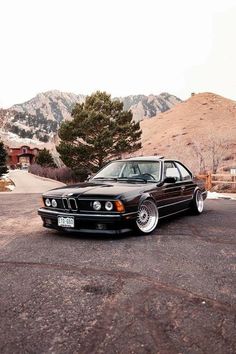 an old bmw is parked in the parking lot