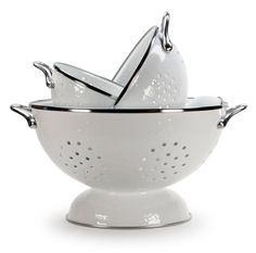 three white colanders stacked on top of each other with silver trim around them