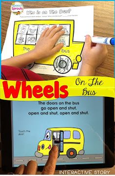 a child is playing on an ipad with the words wheels on the bus written below