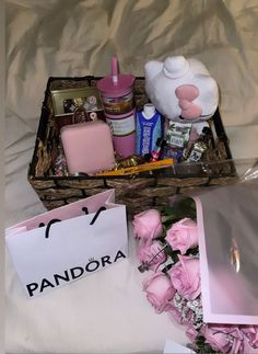 a basket filled with pink flowers next to a white bag and some other items on top of a bed