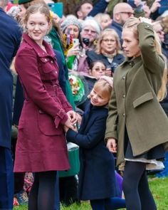 two women and a child are standing in front of an audience with their arms around each other