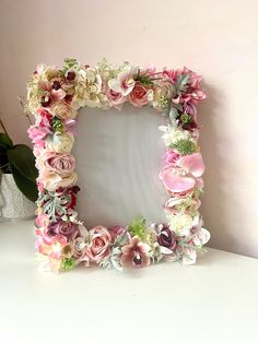 a flowered photo frame sitting on top of a table