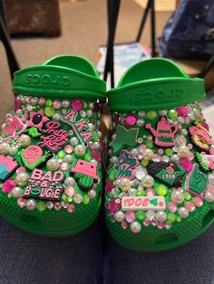 a pair of green clogs with pink and green decorations