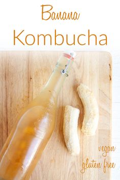 banana kombucha in a glass bottle next to a sliced banana on a cutting board