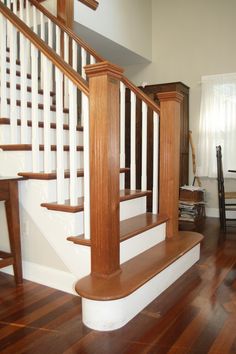 an empty room with wood floors and white railings