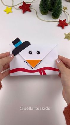 someone is holding an envelope with a snowman on it