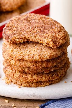 three cookies stacked on top of each other with a glass of milk in the background