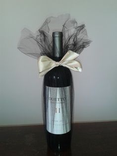 a bottle of wine with a bow on the top is sitting on a wooden table