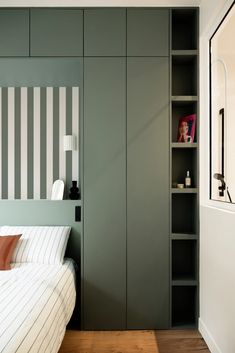 a bed sitting in a bedroom next to a book shelf