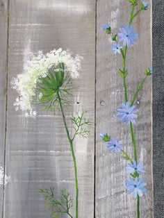 some blue and white flowers sitting on top of a wooden table next to each other