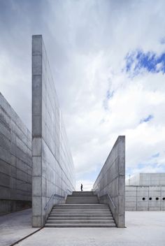 an empty concrete staircase leading up to the top of a building with stairs and railings