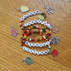 a wooden table topped with bracelets and charms