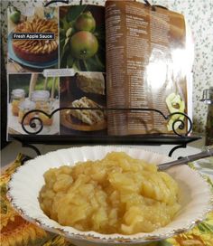 a bowl filled with food sitting on top of a table next to an open book