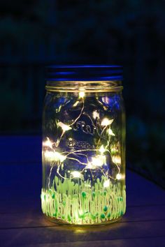 a mason jar filled with fairy lights on top of a table