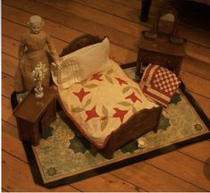 a bed sitting on top of a wooden floor next to a night stand and lamp