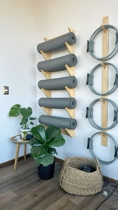 a room with yoga mats and wall hangings on the wall next to a potted plant