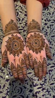 two hands with henna designs on them