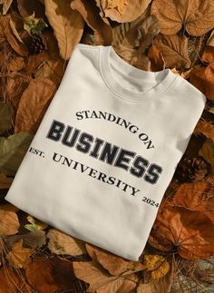 Embrace the spirit of ambition and success with our "Standing On Business University" Shirt, a symbolic piece that represents a commitment to excellence, learning, and entrepreneurial spirit. This shirt isn't just apparel--it's a statement of purpose for current and aspiring business leaders, entrepreneurs, and anyone dedicated to making their mark in the world of business. Crafted from high-quality, soft fabric, it offers both comfort and style for all-day wear, whether you're in the classroom, at the office, or working on your next big project from home. The design is both classic and bold, featuring the prestigious "Standing On Business University" emblem, which signifies your dedication to growth, innovation, and standing firm on your business principles. Perfect for those who value ed Long Sleeve Branded T-shirt For College, Long Sleeve College T-shirt With Branding, Crew Neck Cotton Shirt For College Events, Cotton Crew Neck Shirt For College Events, Business University, Statement Of Purpose, College Shirt, Values Education, University Shirt