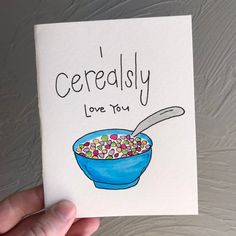 a hand holding up a card with cereal in a blue bowl and the words'cereldsly love you'written on it