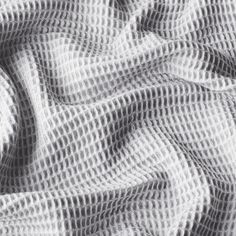 an image of a white and black textured fabric that looks like it has been woven in