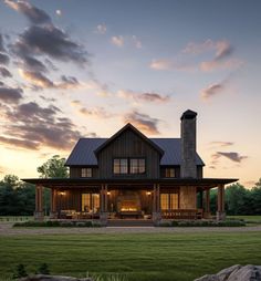 a house that is sitting in the middle of a field with grass and rocks around it