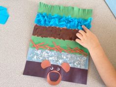 a child's hand on top of a piece of paper that has been made to look like a bear