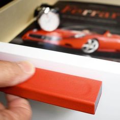 a person holding a red object in front of a book