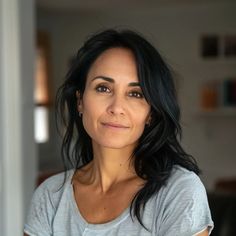 a close up of a person wearing a shirt and looking at the camera with a smile on her face