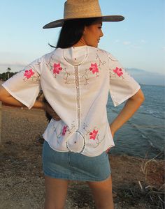 Tie front blouse in white with hand embroidered floral details and crochet panels. V neckline. Short sleeve. Ties to front. Size M, EU 38-42 / UK 10-14. Measurements: 40"/ 102cm bust - 12" / 30cm sleeve length - 25" / 64cm blouse length. Condition - New. Material - Cotton. Sustainability - Remade by our in house team using vintage fabrics. Model is a UK 6/8 & 5'7" tall. Crochet Panels, Embroidered Blouses, Jumpsuit Skirt, Tie Front Blouse, Sleeveless Jacket, Blouse Length, Vintage Fabrics, Beach Wears, Embroidered Blouse