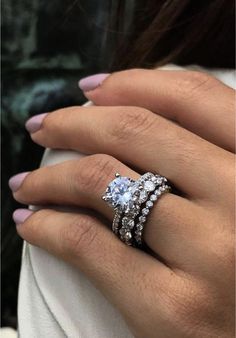 a woman's hand with three diamond rings on her left and the middle finger