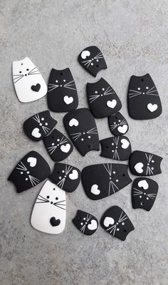 black and white cat magnets with hearts on them are laid out in the shape of cats