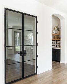 an empty room with glass doors and wood flooring