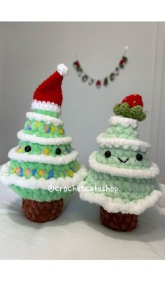 two crocheted christmas trees sitting next to each other