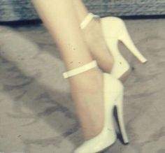 a woman's legs wearing white high heels