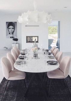 a dining room table with pink chairs around it