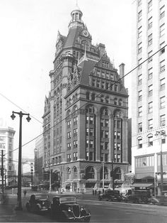 an old black and white photo of a very tall building with a clock on it