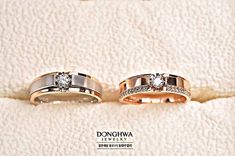 two gold wedding rings with diamonds on white furnishing, one is for him and the other is for her