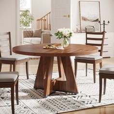 a wooden table with chairs around it and a vase on the dining room table top