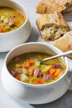 two white bowls filled with soup next to bread